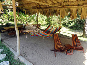 Palapa furnished with hammocks, picnic table and chairs